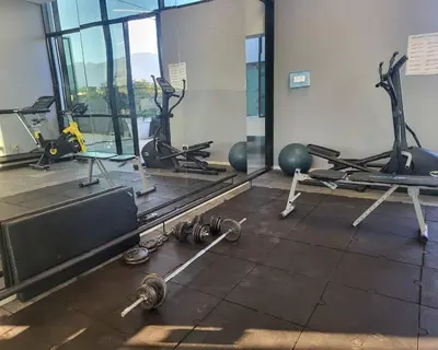 a gym with several treadmills and exercise machines at Luxury apt! Guest friendly! Great location! Jacuzzi, Gym, Security! in Medellín