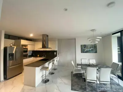 a kitchen with a table and some white chairs at Luxury apt! Guest friendly! Great location! Jacuzzi, Gym, Security! in Medellín