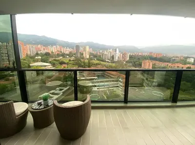 a balcony with chairs and a view of a city at Luxury apt! Guest friendly! Great location! Jacuzzi, Gym, Security! in Medellín