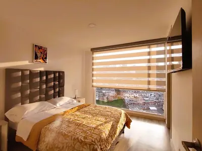 a bedroom with a bed and a large window at BALMORAL in Manizales