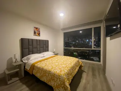 a bedroom with a bed and a large window at BALMORAL in Manizales