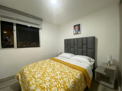 a bedroom with a large bed and a window at BALMORAL in Manizales