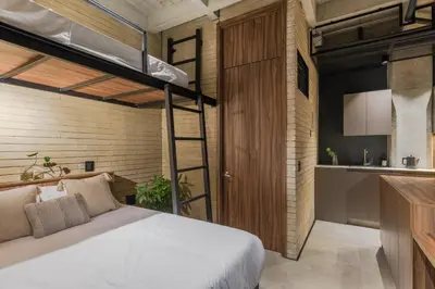 a bedroom with a loft bed and a kitchen at Recinto68 in Medellín
