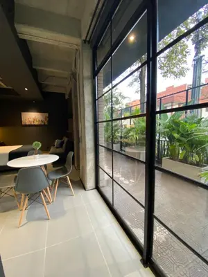 a room with large windows and a table and chairs at Recinto68 in Medellín