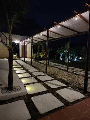 a stone walkway with a palm tree in front of a building at Eco hotel Torino in Tarso