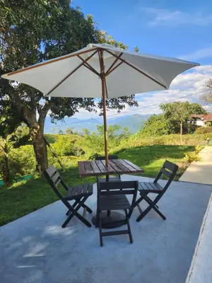 a picnic table and two chairs under an umbrella at Eco hotel Torino in Tarso