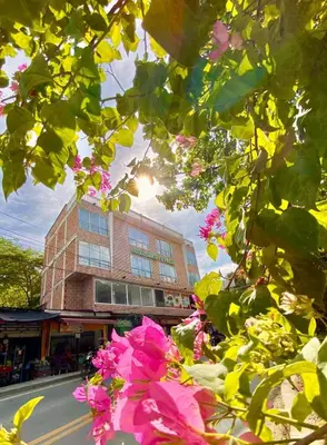 a building with pink flowers in front of a street at Hotel santa fe plaza sucursal HBP in Santa Fe de Antioquia