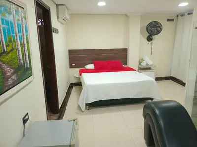 a bedroom with a bed with red pillows on it at Hotel santa fe plaza sucursal HBP in Santa Fe de Antioquia