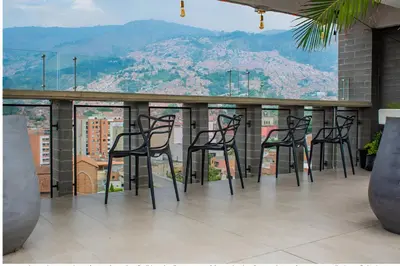 a group of black chairs on a balcony with a view at INVERSO Coliving in Medellín