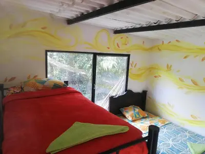 a bedroom with a red bed and a window at Hospedaje Pa'Gaïa in San Rafael