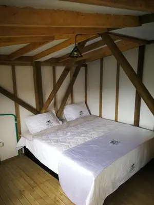 a white bed in a room with wooden ceilings at Hillside Cabins - Guatapé in Medellín