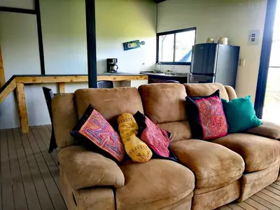 a brown couch with pillows on it in a living room at Hillside Cabins - Guatapé in Medellín