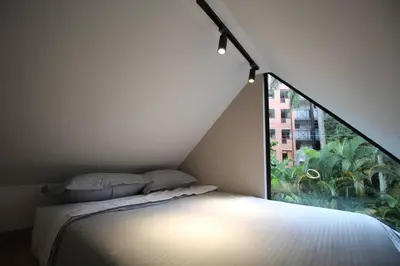 a bedroom with a bed and a large window at Nueva Tiny House en el Poblado FRN110 By Roots Rentals in Medellín