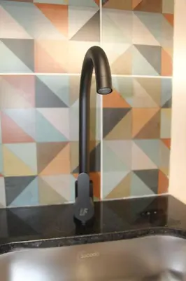 a kitchen sink with a black faucet on a counter at Nueva Tiny House en el Poblado FRN110 By Roots Rentals in Medellín