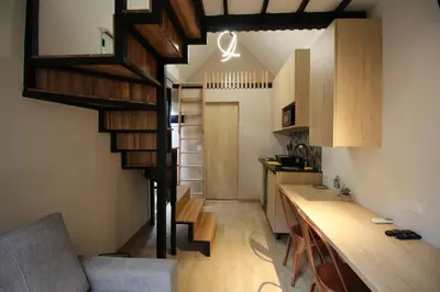a small kitchen with a spiral staircase in a room at Nueva Tiny House en el Poblado FRN110 By Roots Rentals in Medellín