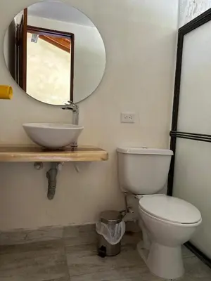 a bathroom with a white toilet and a mirror at Casa Fuego in La Pintada