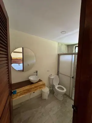a bathroom with a toilet and a sink and a mirror at Casa Fuego in La Pintada