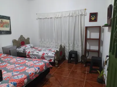 a bedroom with two beds and a mirror at Casa Rio y Montaña Low cost in Honda
