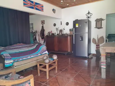 a living room with a refrigerator and a table at Casa Rio y Montaña Low cost in Honda
