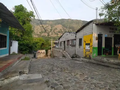 an empty street next to a building with a mountain at Casa Rio y Montaña Low cost in Honda