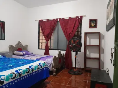 a bedroom with two beds and a fan and a window at Casa Rio y Montaña Low cost in Honda