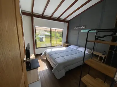 a bedroom with a bed and a large window at Casa campestre descanso relajación jacuzzi BBQ amplias zonas verdes in Carmen de Viboral