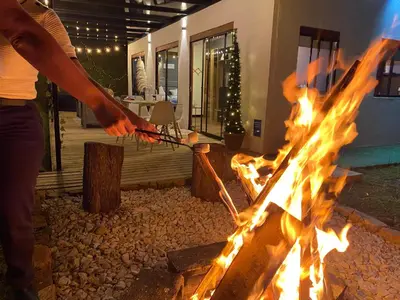 a person is standing over a fire grill at Casa campestre descanso relajación jacuzzi BBQ amplias zonas verdes in Carmen de Viboral