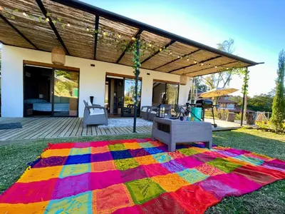 a colorful rug on the grass in front of a house at Casa campestre descanso relajación jacuzzi BBQ amplias zonas verdes in Carmen de Viboral