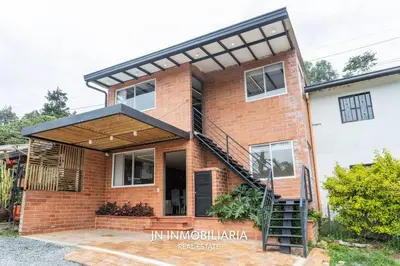 a brick house with a black roof at Nuevo Apartamento a 2 minutos del JMC jacuzzi in Rionegro