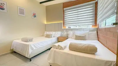 two beds in a room with a window at Nuevo Apartamento a 2 minutos del JMC jacuzzi in Rionegro