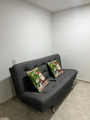 a black couch with two christmas pillows on it at Apartamento Nogales in Bello