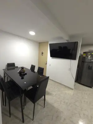 a dining room with a table with chairs and a television at Apartamento Nogales in Bello