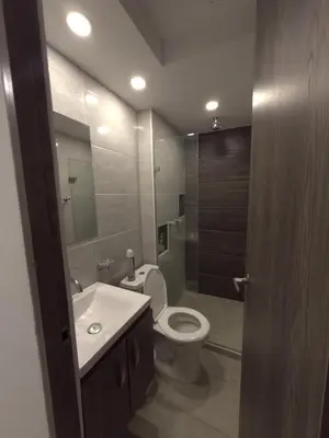 a bathroom with a toilet and a sink and a mirror at Apartamento Nogales in Bello