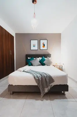 a bedroom with a large bed with green pillows at AC - House Laureles - Self Cheking in Medellín