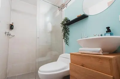 a bathroom with a toilet and a sink and a shower at AC - House Laureles - Self Cheking in Medellín