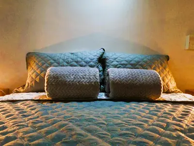 a bed with pillows on it in a bedroom at Azulejo - Guest House in Medellín
