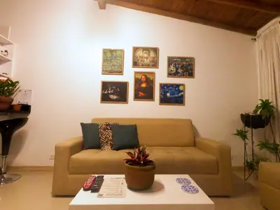 a living room with a couch and pictures on the wall at Azulejo - Guest House in Medellín