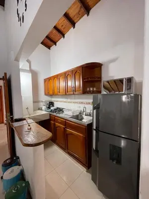 a kitchen with wooden cabinets and a stainless steel refrigerator at Apartamento 501 in Itagüí