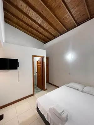 a bedroom with a white bed and a flat screen tv at Apartamento 501 in Itagüí