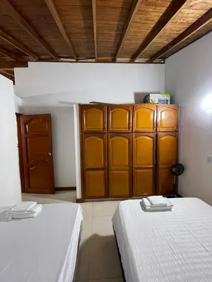 a room with two beds and a wooden cabinet at Apartamento 501 in Itagüí