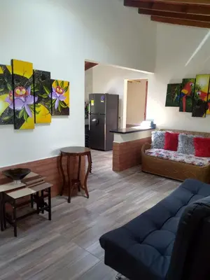 a living room with a couch and a kitchen at Villa Yolanda in Girardota