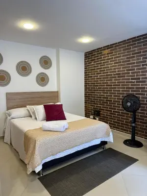 a bedroom with a bed and a brick wall at Great Apto in Poblado in Medellín
