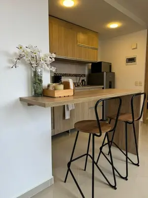 a kitchen with a counter with two chairs and a vase with flowers at Great Apto in Poblado in Medellín