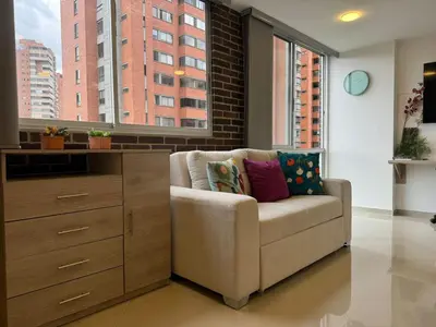 a living room with a chair and a dresser at Great Apto in Poblado in Medellín
