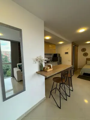 a kitchen and living room with a counter and chairs at Great Apto in Poblado in Medellín