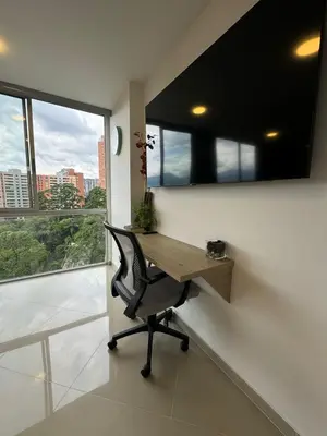 an office with a desk and a chair and windows at Great Apto in Poblado in Medellín