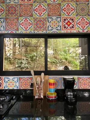 a kitchen counter with a window with a patterned wall at nido de montaña in Copacabana