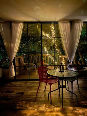 a dining room with a table and chairs and a window at nido de montaña in Copacabana