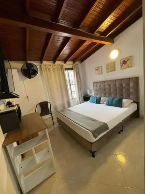 a bedroom with a large bed and a television at Hotel boutique San Pablo H10 in Medellín