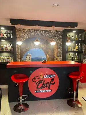 a bar with two red stools and a lucky chef restaurant at Hotel boutique San Pablo H10 in Medellín